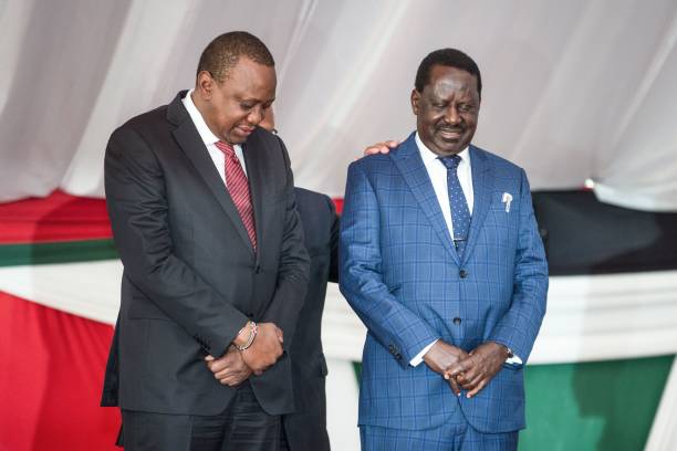 Kenya's President Uhuru Kenyatta and opposition leader Raila Odinga pray together on a stage during the annual prayer breakfast for unity of the...