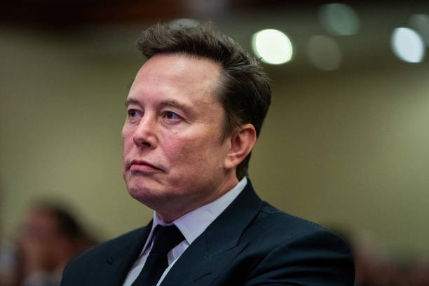Elon Musk listens as US President-elect Donald Trump speaks during a House Republicans Conference meeting at the Hyatt Regency on Capitol Hill on...